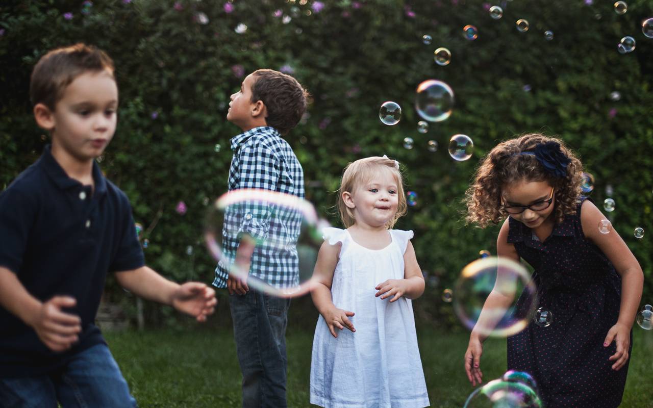 Kinder spielen mit Seifeblasen