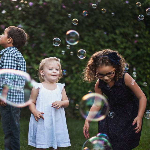 Kinder spielen mit Seifeblasen