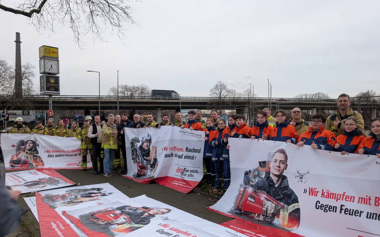 Die Freiwillige Feuerwehr und die Jugendfeuerwehr zeigen die Banner in die Kamera
