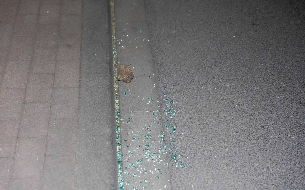 Stein liegt mit Glasscherben auf der Straße.