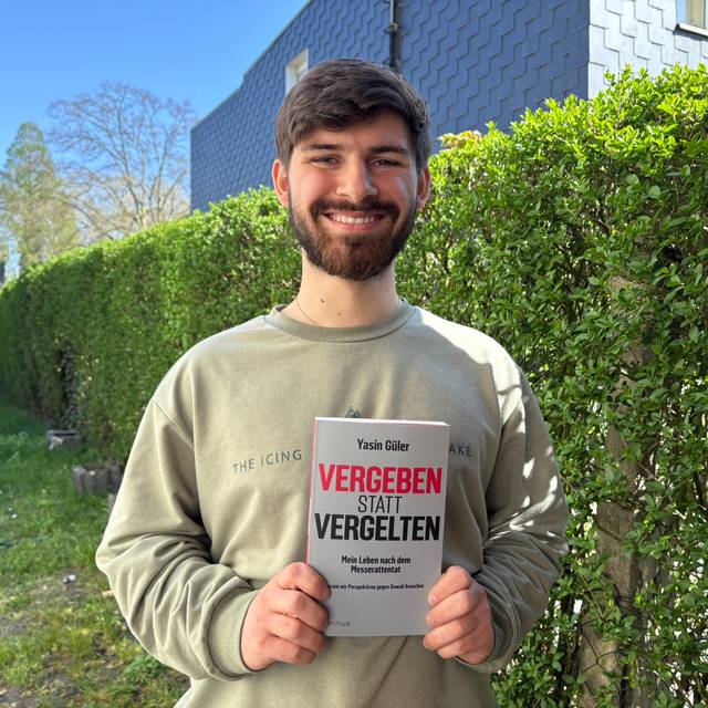 Yasin Güler hält sein neu erschienenes Buch in der Hand: "Vergeben statt Vergelten".