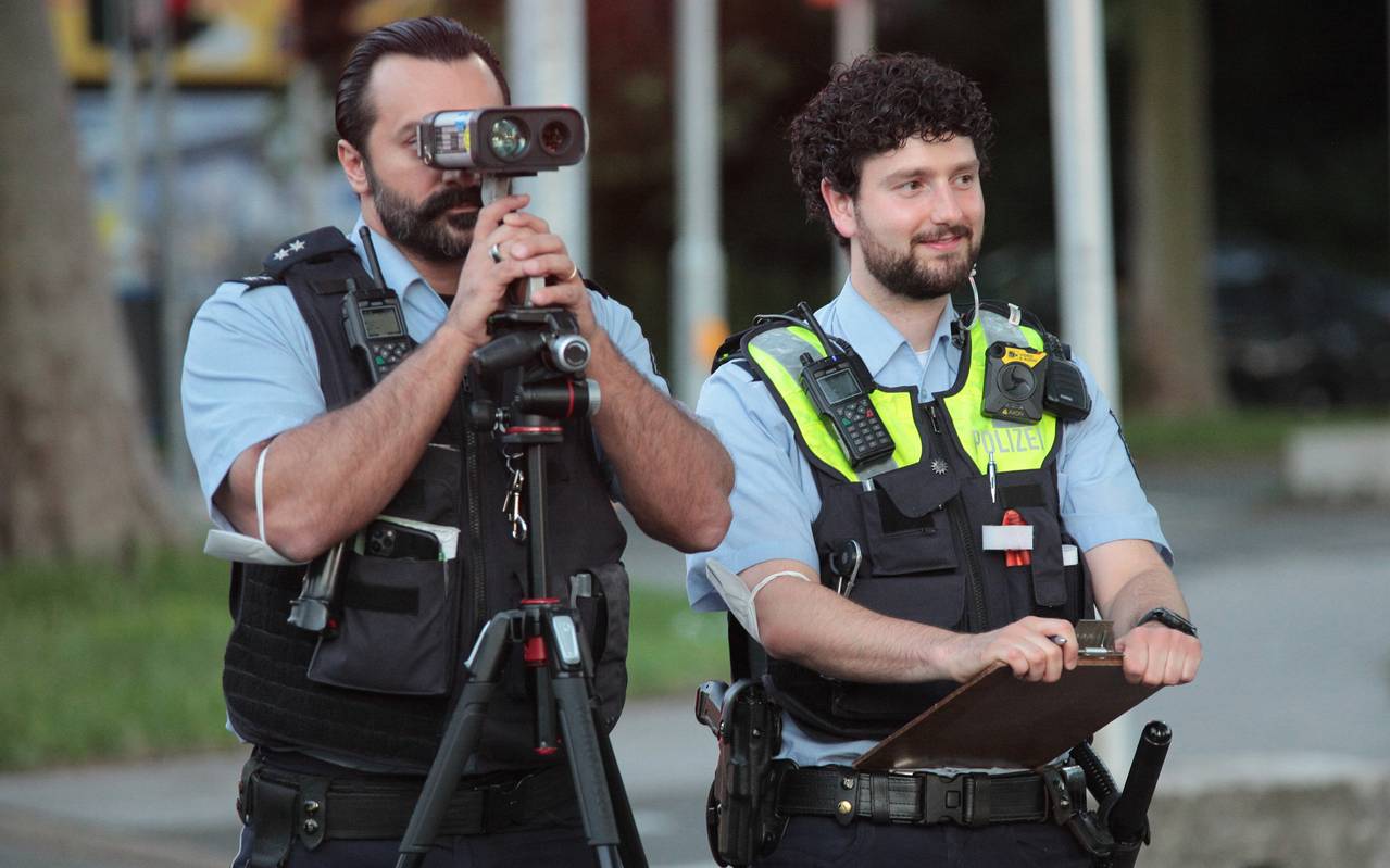 Zwei Polizisten kontrollieren Fahrzeuge mit einem Radar-Gerät.