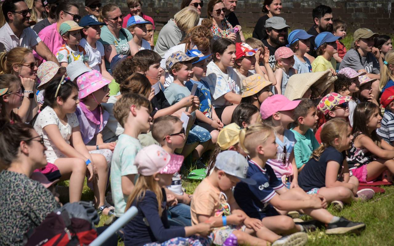 Kinder sitzen auf einer Wiese beim KinderKulturFestival in Duisburg