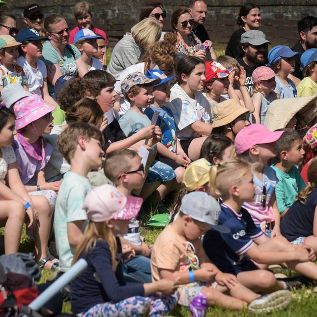 Kinder sitzen auf einer Wiese beim KinderKulturFestival in Duisburg