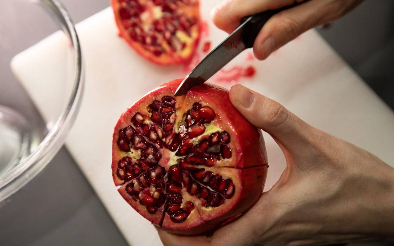 Granatapfel wird entlang der Kammern eingeschnitten