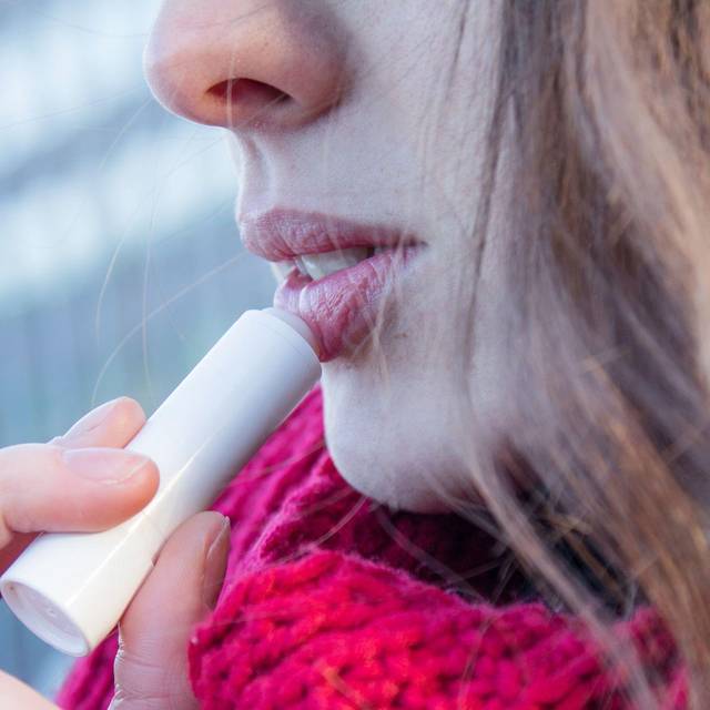 Frau trägt eine Lippenpflege auf