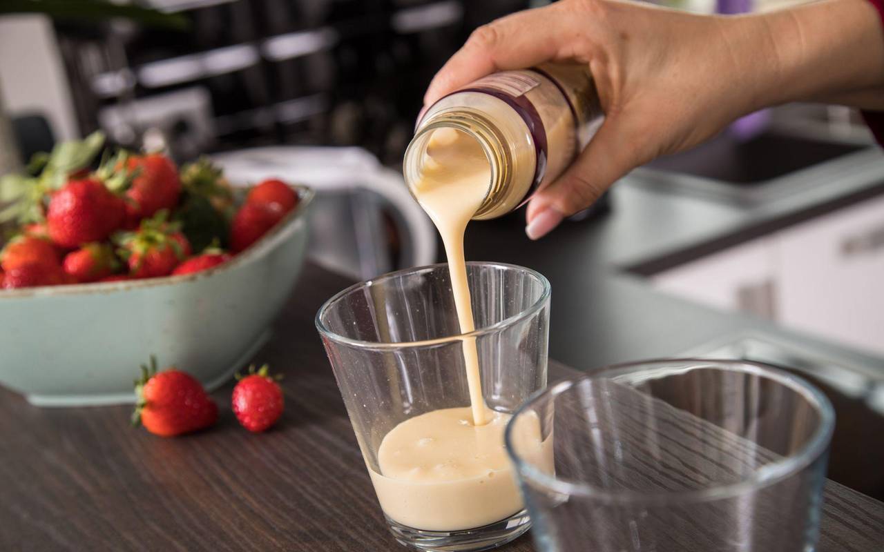 Eine Frau gießt ein Fertig-Getränk in ein Glas