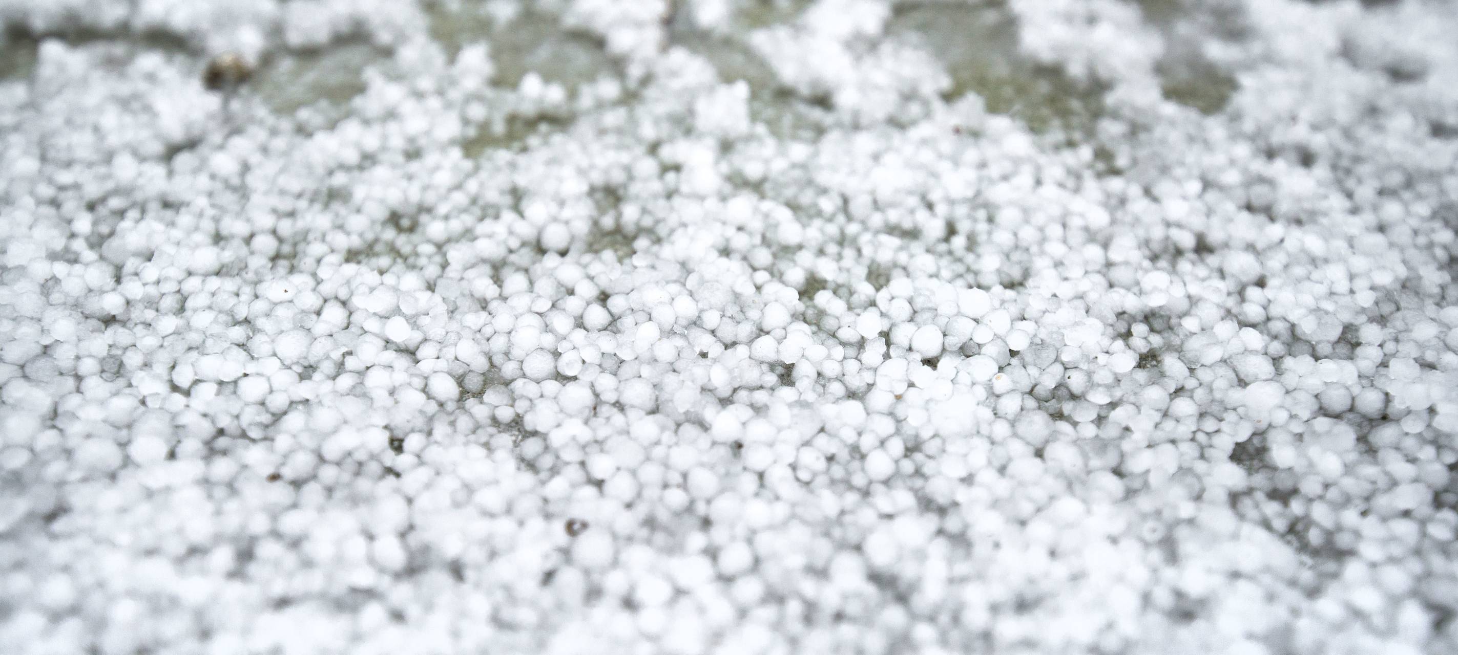Hagelkörner liegen auf dem Boden (Symbolbild).