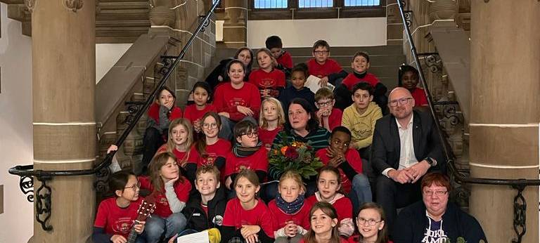 Die Schulkinder hinter dem Christbaumschmuck zusammen mit OB Link.