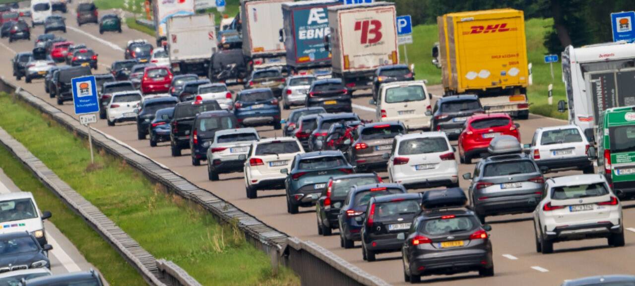 PKW und LKW stauen sich während des Rückreiseverkehr auf der Autobahnen A8 bei Holzkirchen.