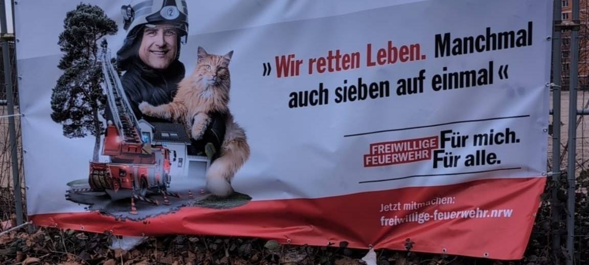 Ein neues Feuerwehrbanner an einem Bauzaun