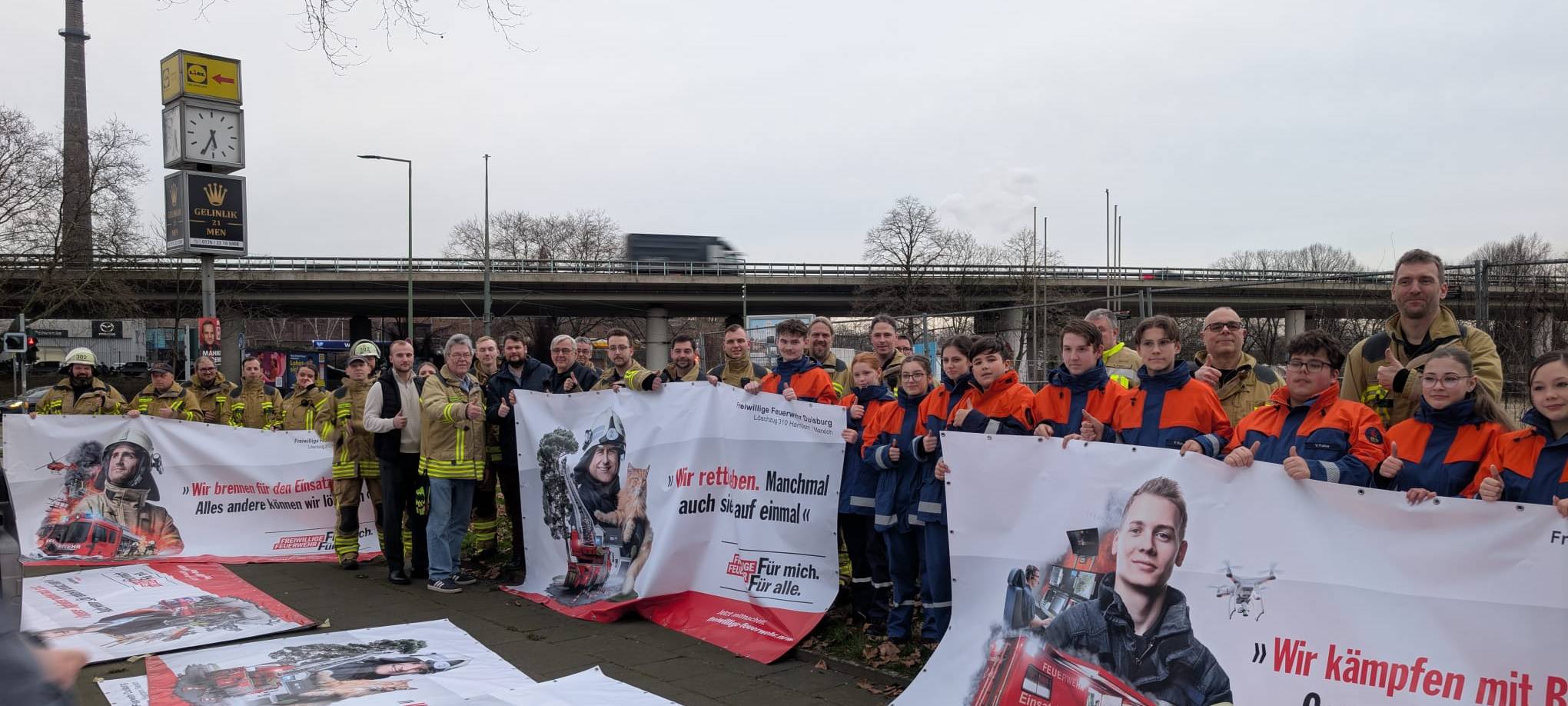 Die Freiwillige Feuerwehr und die Jugendfeuerwehr zeigen die Banner in die Kamera