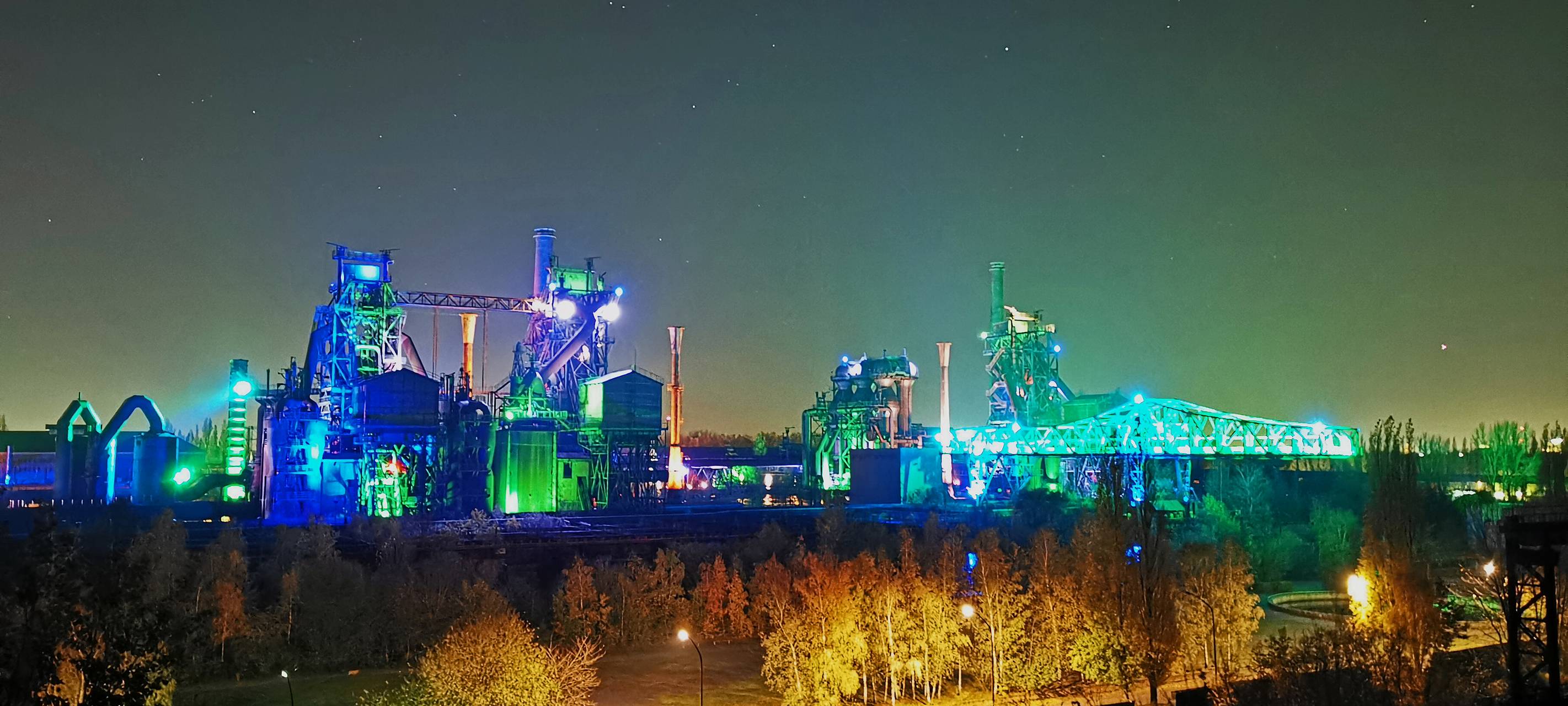 Landschaftspark Duisburg-Nord leuchtet nachts in verschiedenen Farben.
