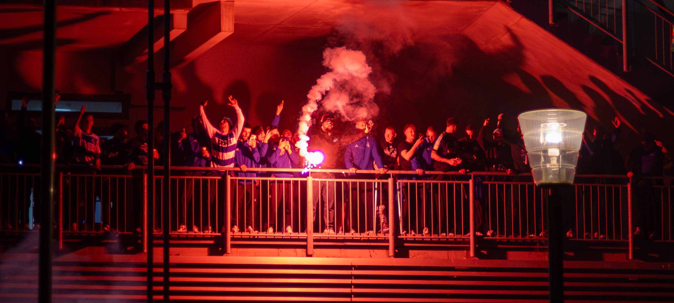 Die Aufstiegsmannschaft feiert mit Pyrotechnik in der Hand den Aufstieg am Stadion.