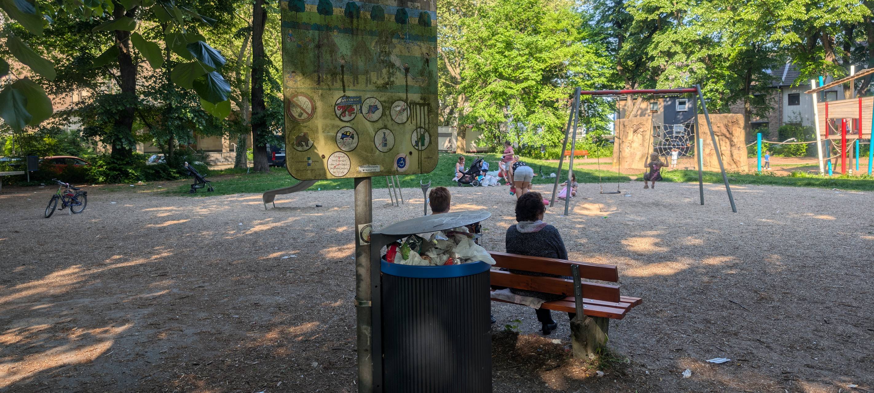 Ein Schild vor einem Spielplatz weist die Besucher darauf hin, keine Hunde mitzubringen und Müll wegzuschmeißen oder wieder mitzunehmen.
