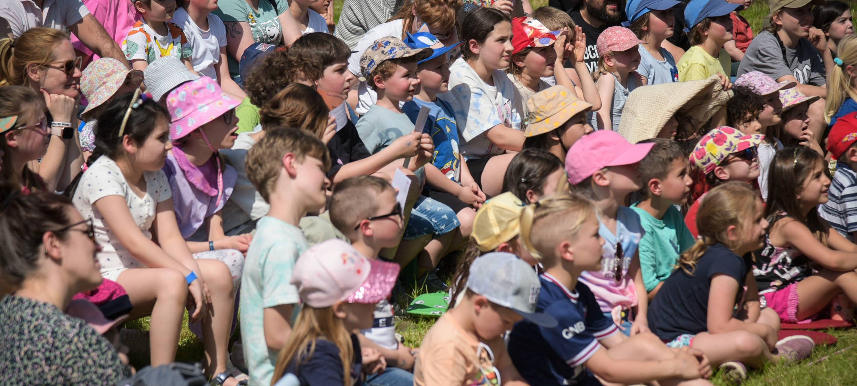 Kinder sitzen auf einer Wiese beim KinderKulturFestival in Duisburg