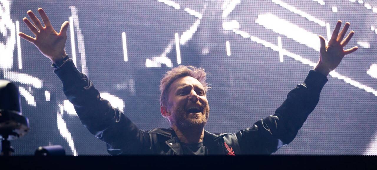 DJ David Guetta steht bei seinem Konzert anlässlich der Taufe für die neue AIDAnova an der Meyer Werft mit ausgestreckten Armen feiernd auf der Bühne.