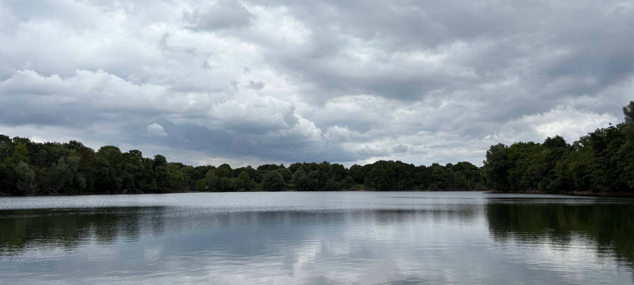 Der Uettelsheimer See in Duisburg lädt mit seinem ruhigen Wasser und grünen Ufer zum Entspannen und Spaziergehen ein.