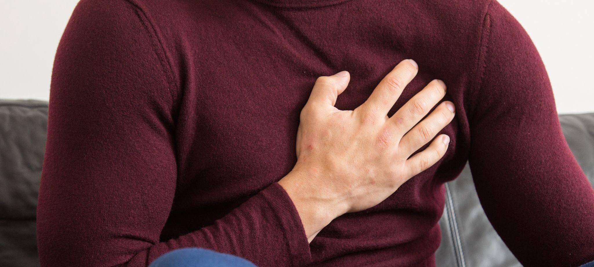 Ein Mann hält sich vor Brustschmerzen die Brust