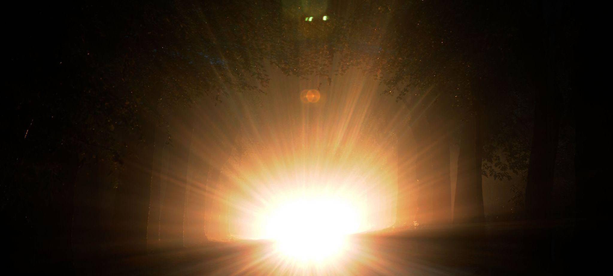 Auto mit Aufblendlicht bei Nacht