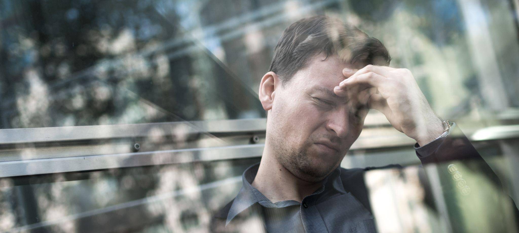 Gestresster Mann greift sich an die Stirn