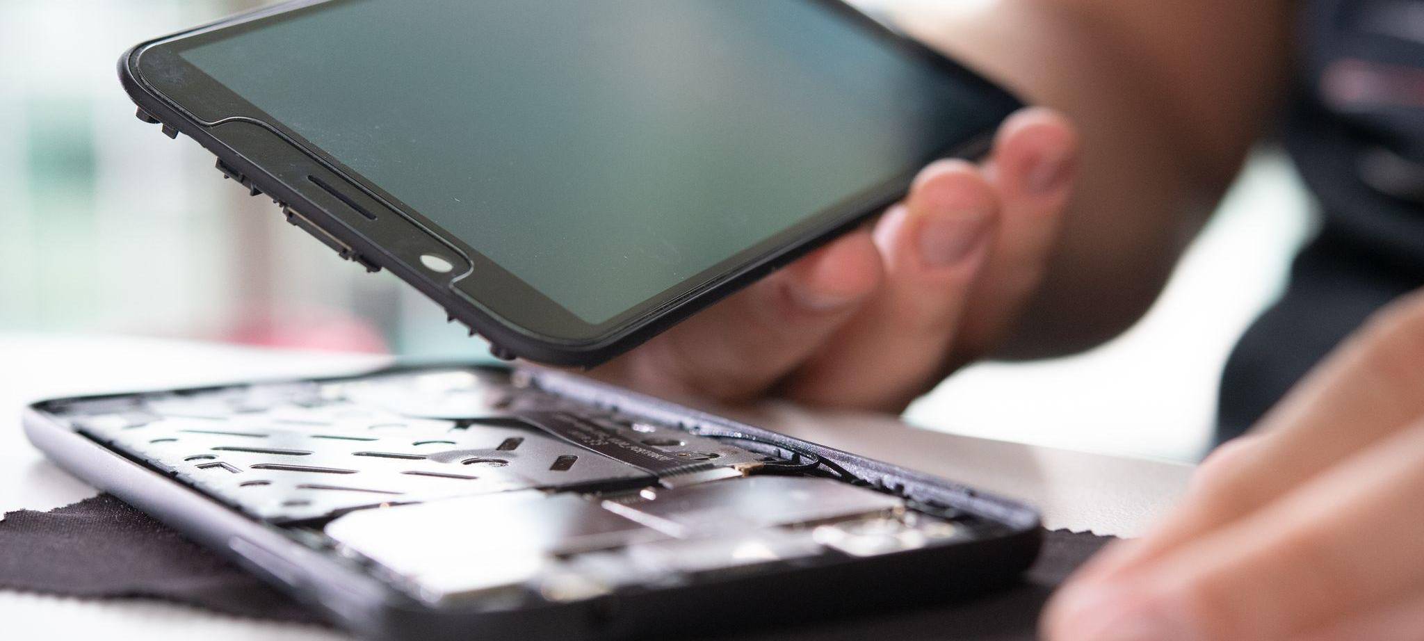 Mann baut ein Smartphone auseinander
