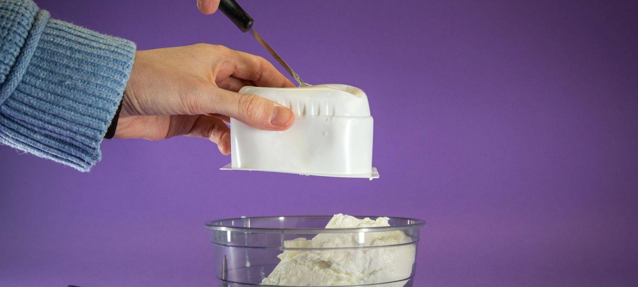 Quark wird aus der Packung in eine Schale gedrückt