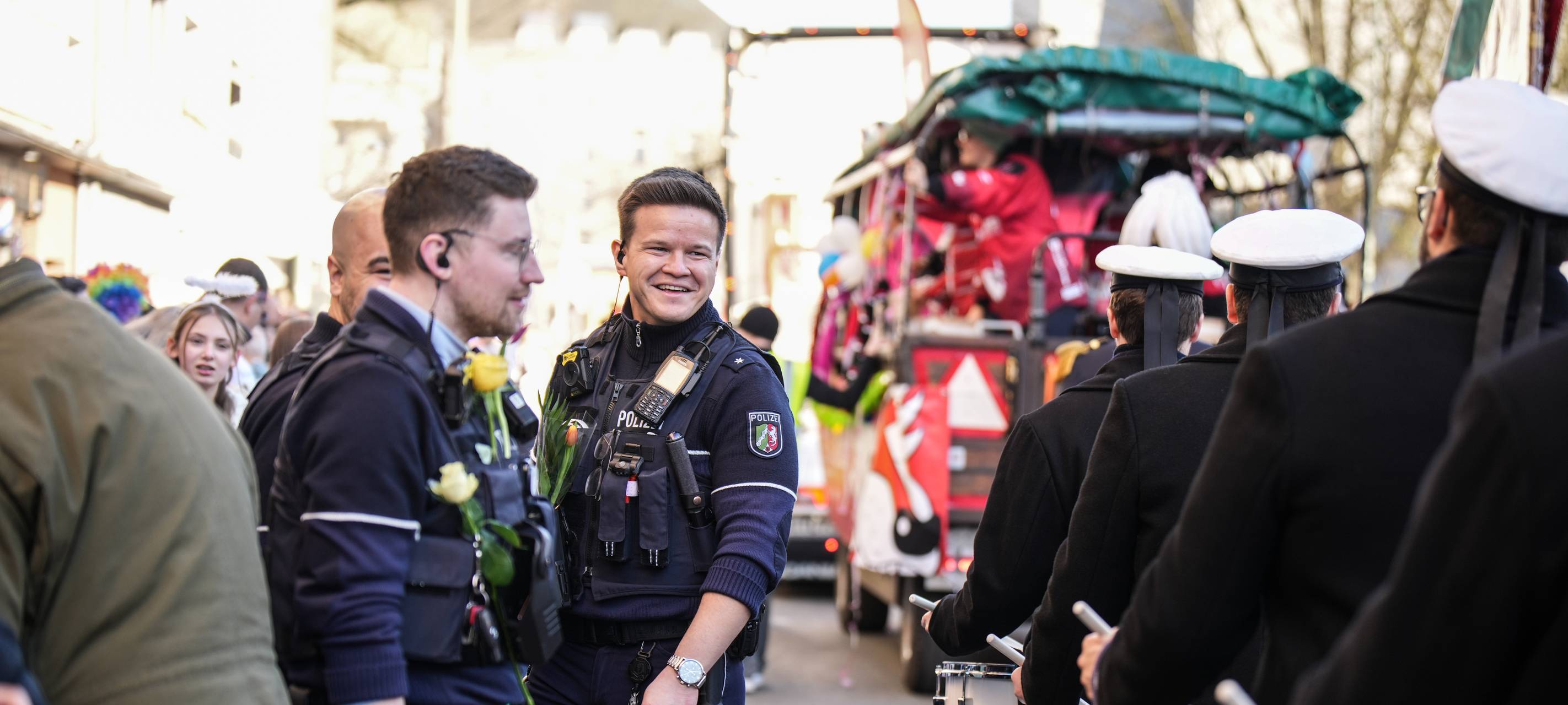 Zwei Polizisten lächelnd inmitten des Duisburger Karnevals.