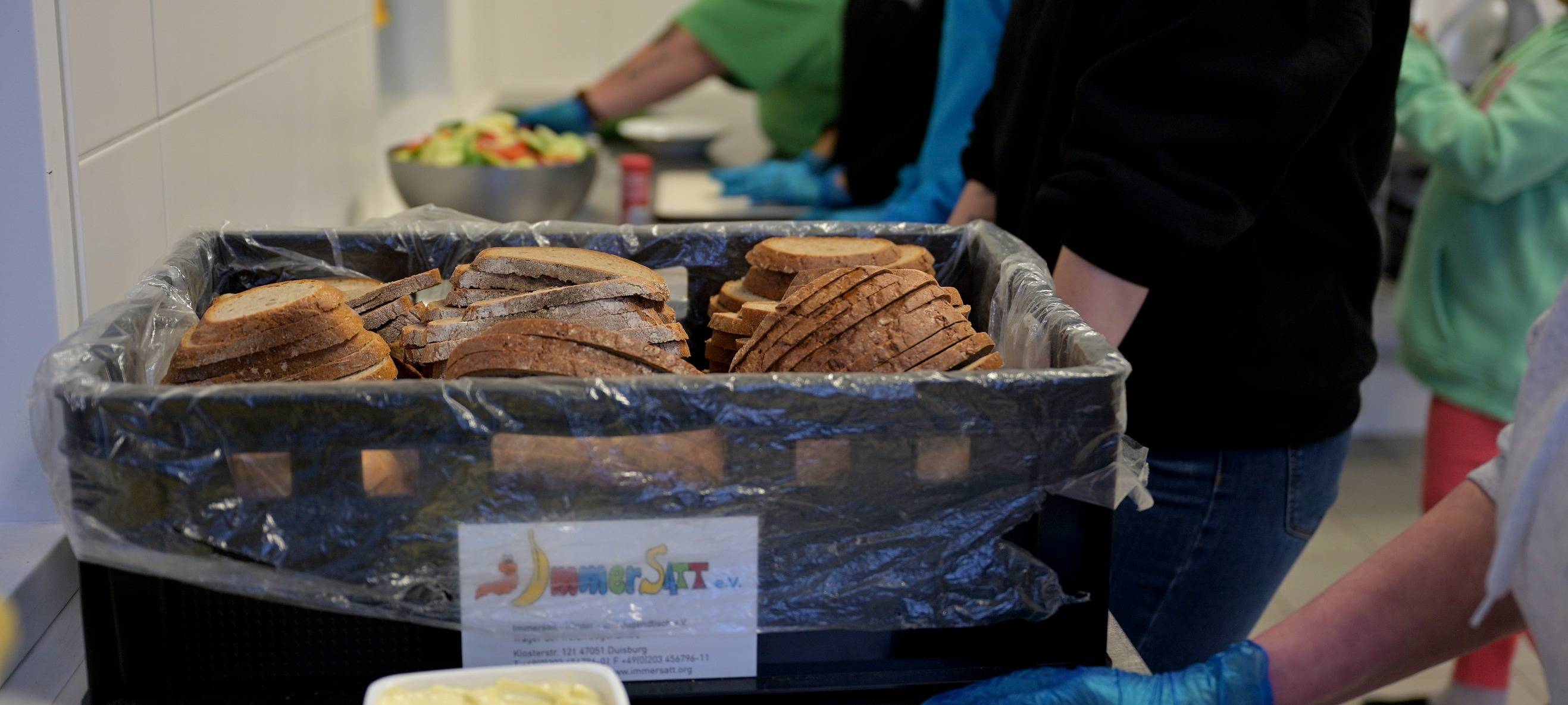 Mitarbeitende von Immersatt schmieren Pausenbrote für rund 900 Duisburger Kinder.