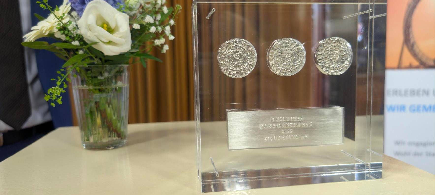 Drei silberne Münzen eingefasst in eine Glastrophäe - das ist der Kaisermünzenpreis.