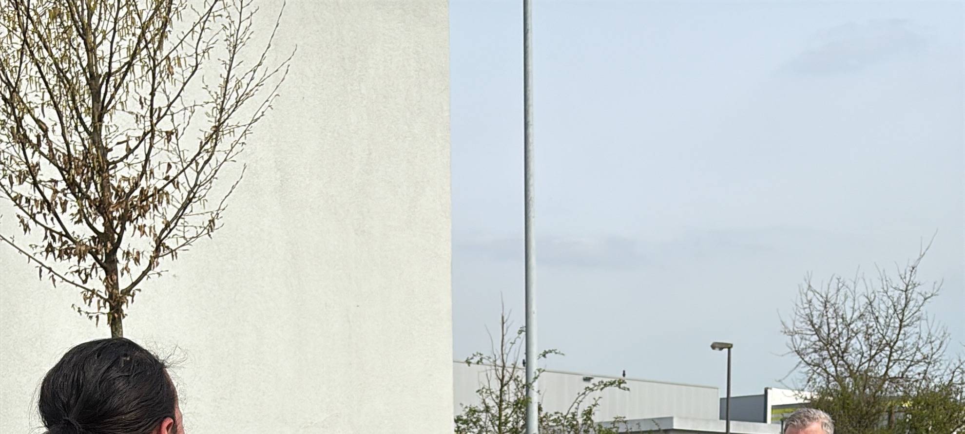 Eine Briefzustellerin steht einem Hund gegenüber, der sie gleich in einem Trainings angreifen wird.