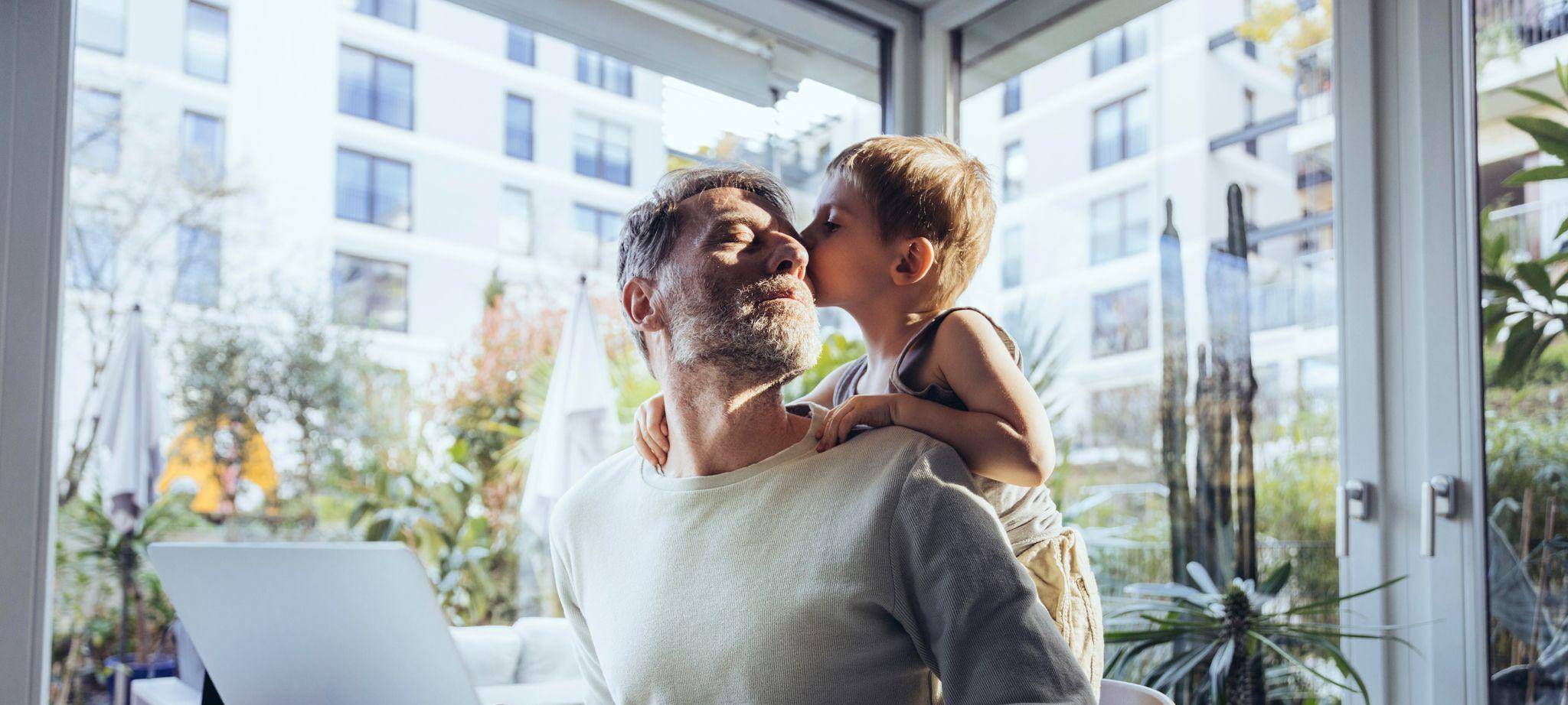 Mann mit Sohn arbeitet im Homeoffice