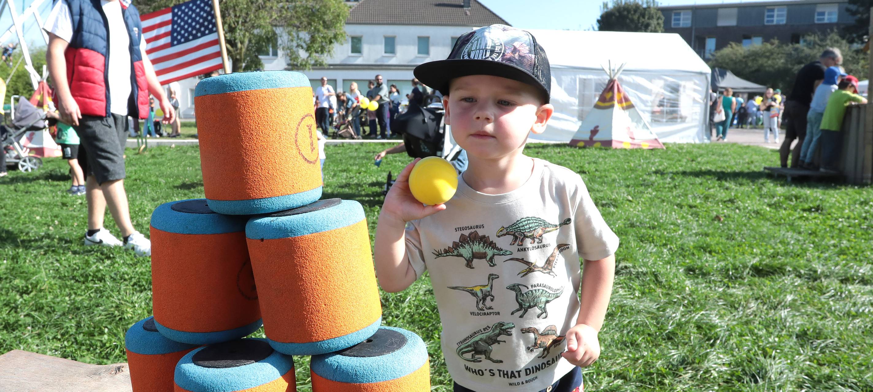 Ein Junge wirft einen Ball auf einen Dosenturm beim Weltkindertag im Duisburger Innenhafen.